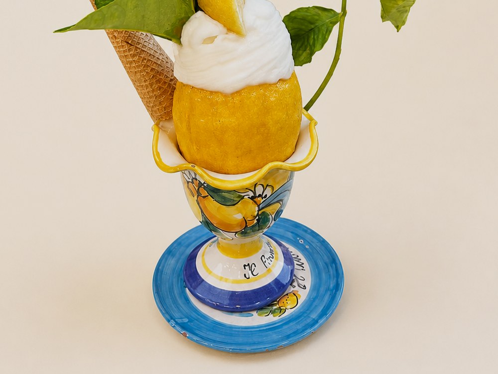 Zitronensorbet in einer ausgehöhlten Zitrone, serviert auf handbemalter Keramik