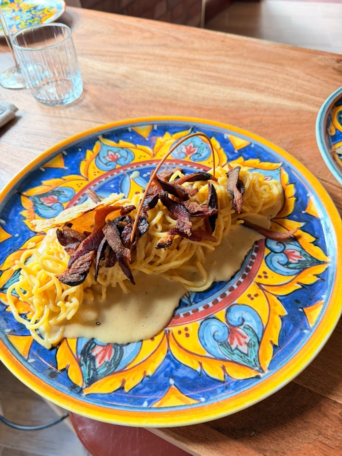Carbonara mit knusprigem Guanciale auf handbemaltem Majolika-Teller