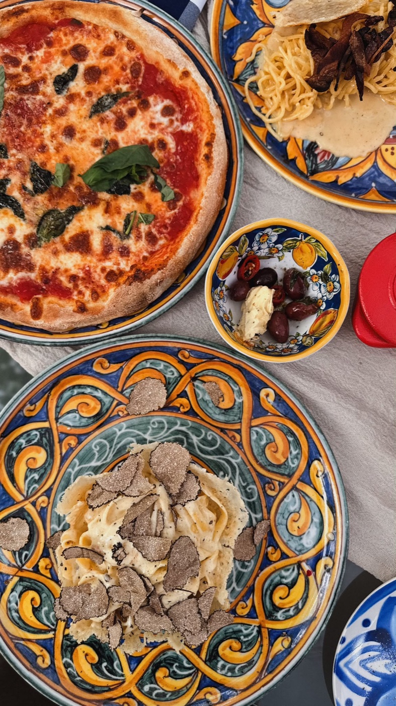 Pizza Margherita, Tagliatelle al Tartufo und Oliven auf handbemalten Majolika-Tellern